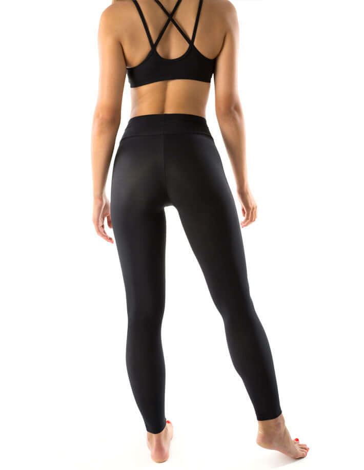 Rückansicht einer Frau in Mid Rise Sportleggings, die dehnbar und hochwertig sind.